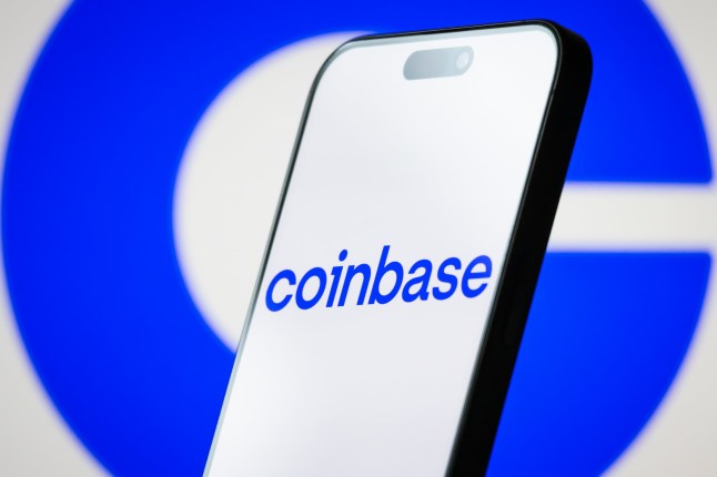 CHONGQING, CHINA - MAY 06: In this photo illustration, the logo of Coinbase Global, Inc. is displayed on a smartphone screen, with the company's signature blue branding visible in the background, on May 06, 2025, in Chongqing, China. Coinbase is an American multinational cryptocurrency exchange platform that allows users to buy, sell, and store digital assets such as Bitcoin, Ethereum, and other cryptocurrencies. (Photo illustration by Cheng Xin/Getty Images)